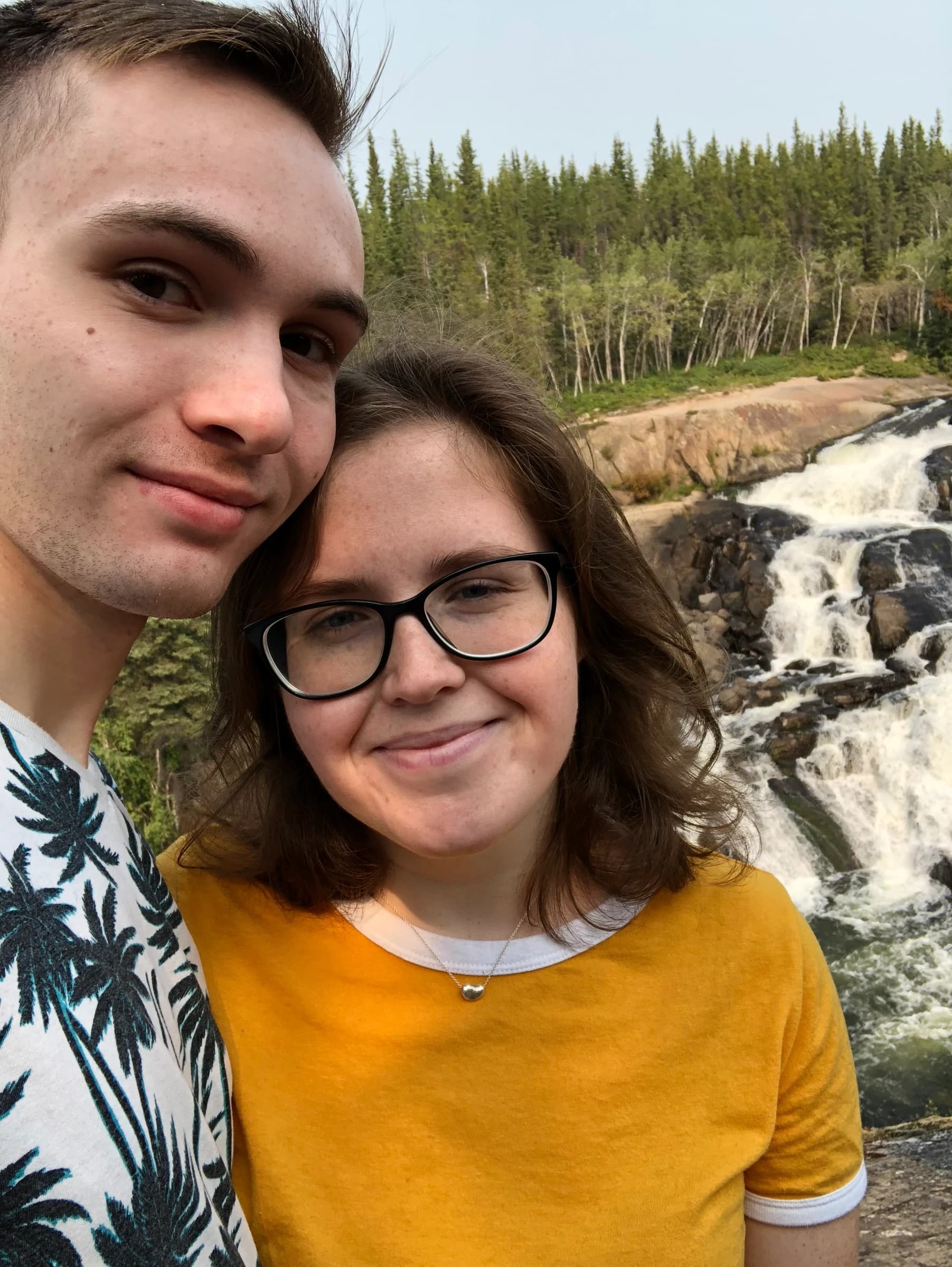 Rachel and Reid in front of a waterfall near Yellowknife