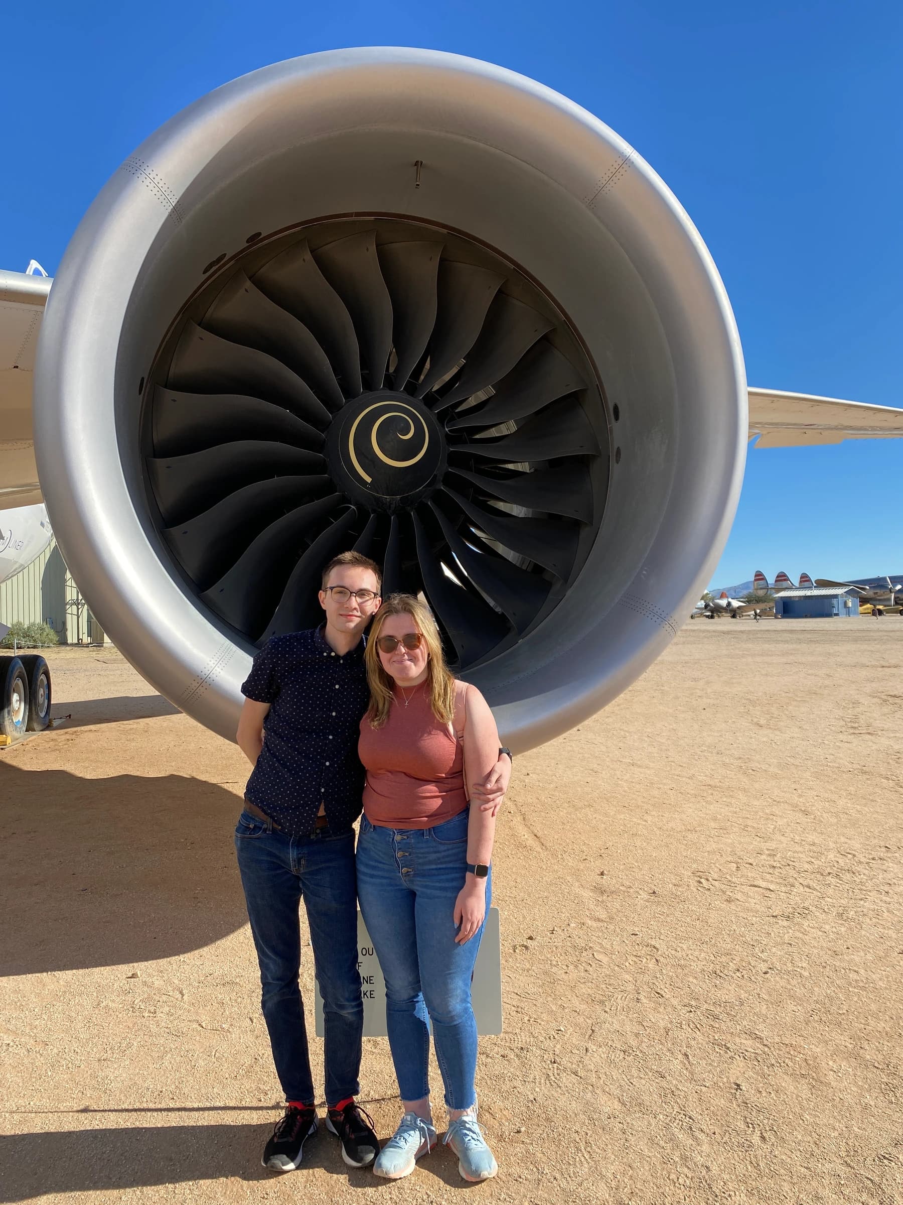 Rachel and Reid standing in front of an enormous jet engine