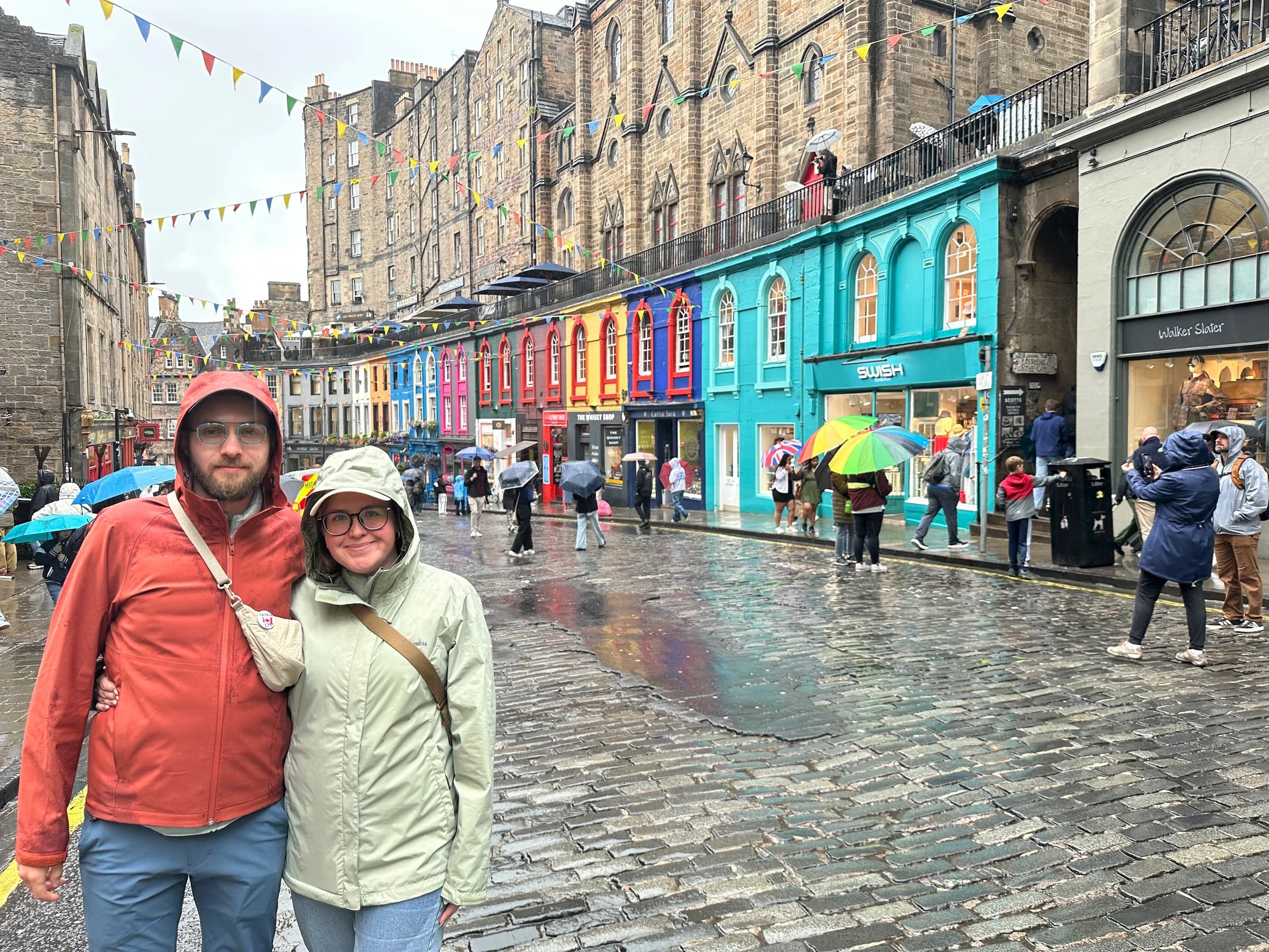 Rachel and Reid in rain jackets on Victoria Street in Edinburgh