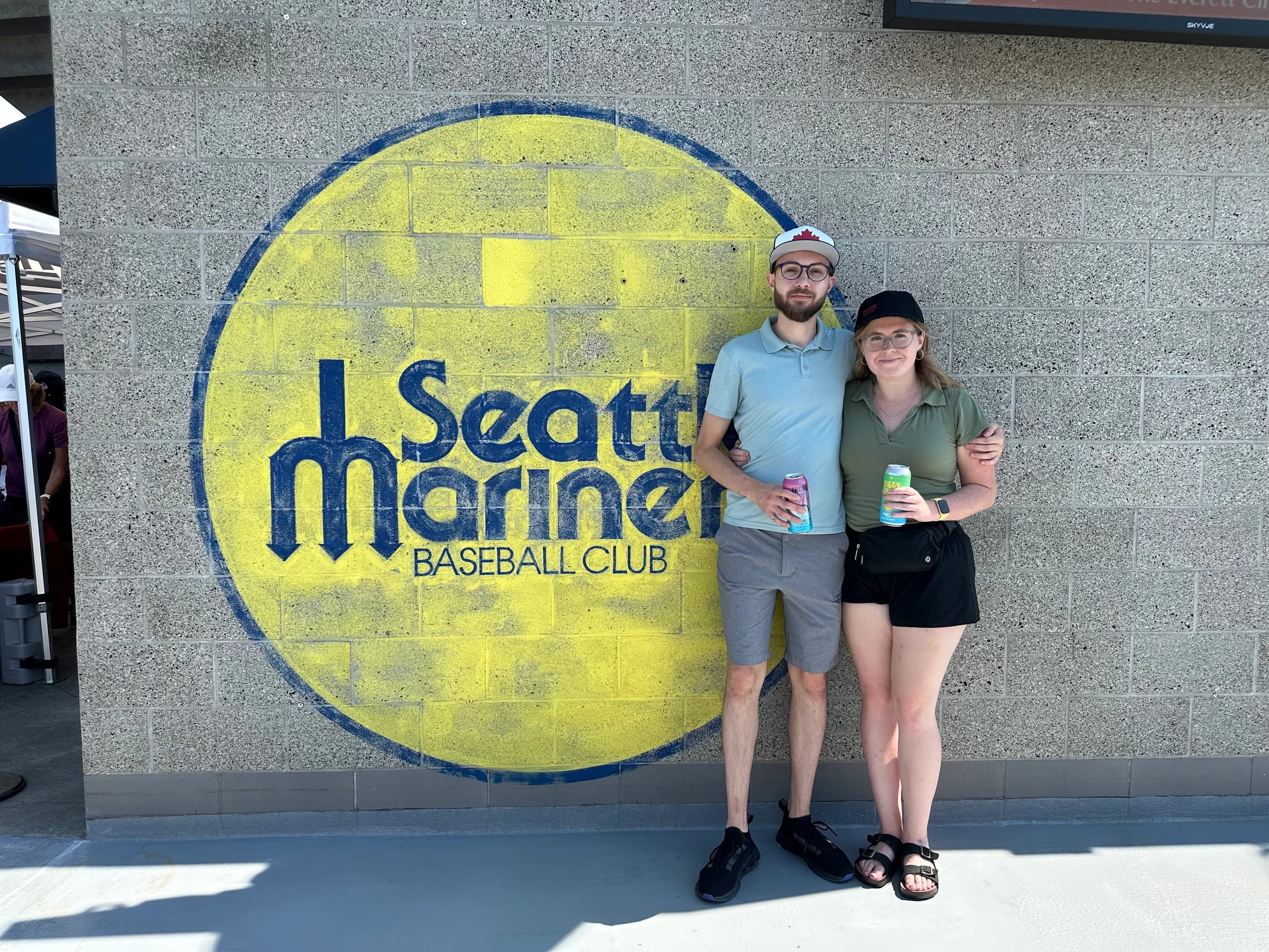Rachel and Reid in front of a painted Seattle Mariners logo